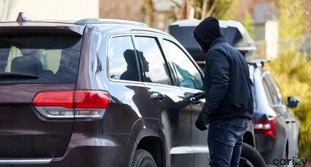 voleur face à une voiture dans une rue