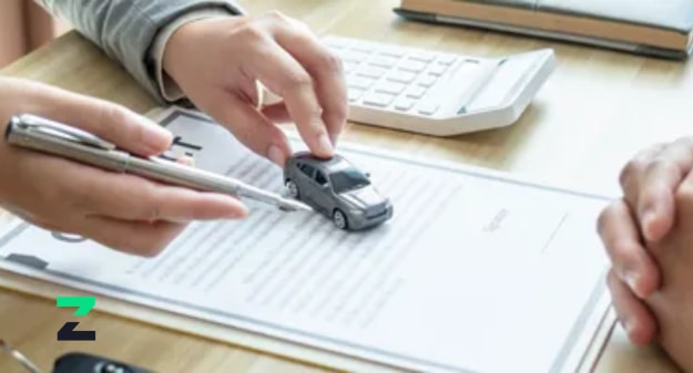 mains autour d'un papier avec une petite voiture dessus